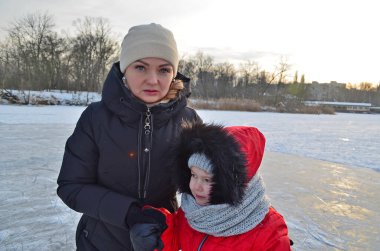 Anne ve kızı donmuş bir nehirde buz üstünde kayıyorlar..