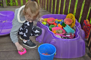 Çocuk bir kız oyuncaklarla oynuyor..