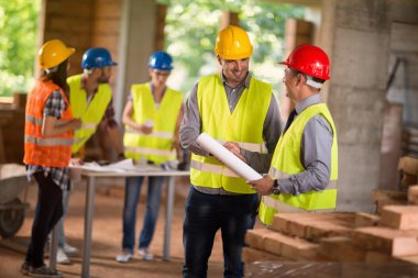 Mimar ve üniforma el sıkışma inşaat sitesinde 