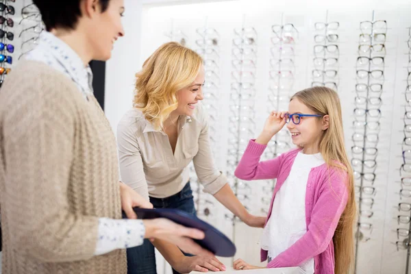 Meisje en haar moeder houdt van blauwe kader voor brillen — Stockfoto