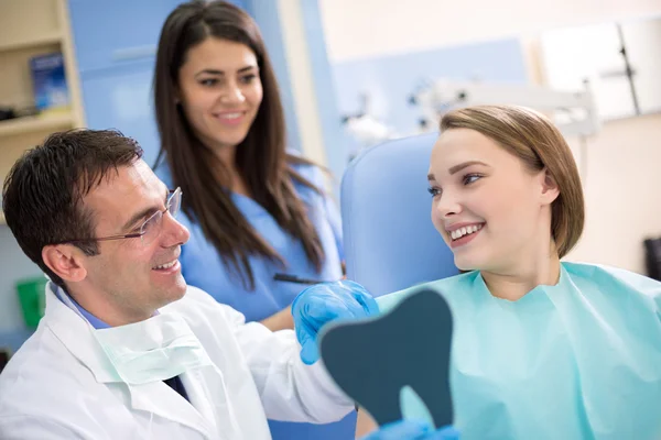 Fille dans une chaise de dentiste avec dentiste après le traitement — Photo