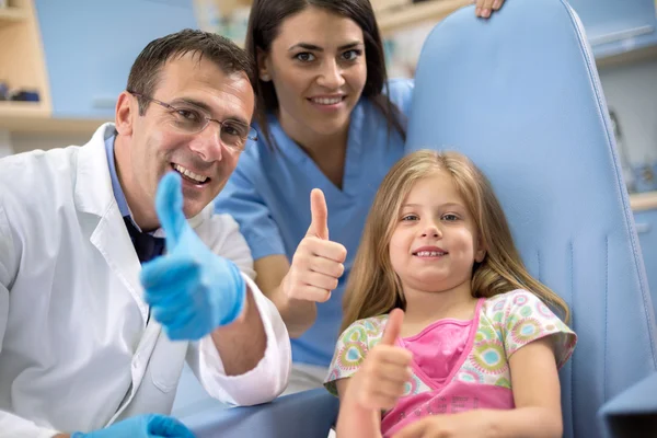 Dentista con assistente e giovane paziente mostra pollice in su — Foto Stock