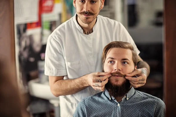 Hábil barbero macho está sirviendo a su cliente — Foto de Stock