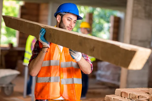 Trabajador traer madera de construcción — Foto de Stock