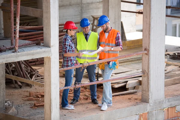 Equipo de arquitectos que buscan plan en el sitio — Foto de Stock