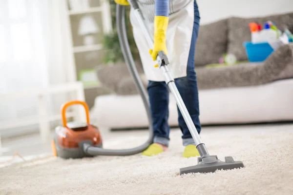 家庭主妇与真空吸尘器清洁地毯 — 图库照片