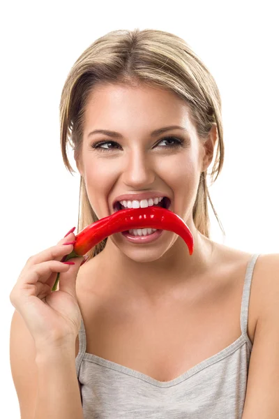 Mulher engraçada mordendo pimenta quente — Fotografia de Stock