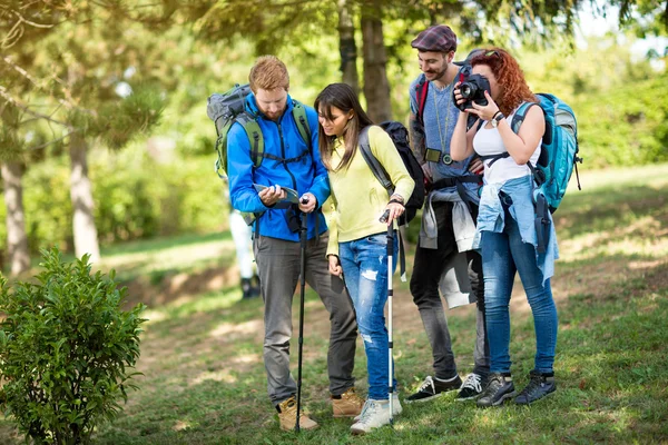 Los excursionistas con mochila toman fotos y ven el camino en el mapa — Foto de Stock