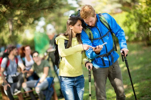 Guy and girl  looks at map on pause — Stock Photo, Image