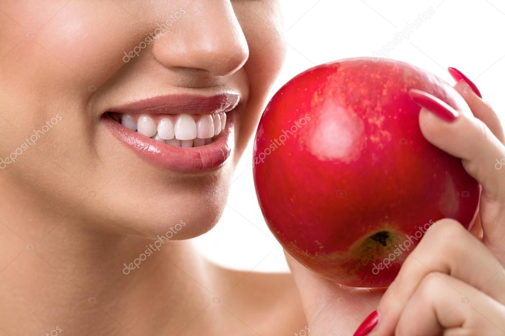 Female open mouth with perfect teeth and red apple 