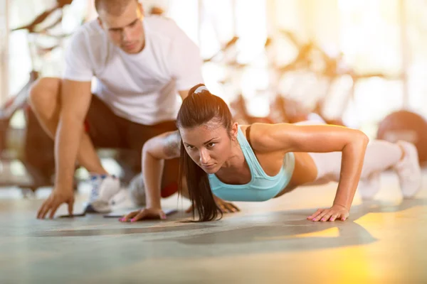 Kadının yapması Push ups bir eğitmen gözetimi altında — Stok fotoğraf