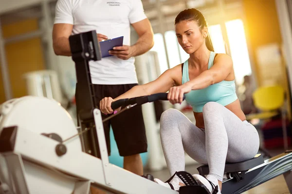 Instructeur prenant des notes de femme sportive dans la salle de gym — Photo