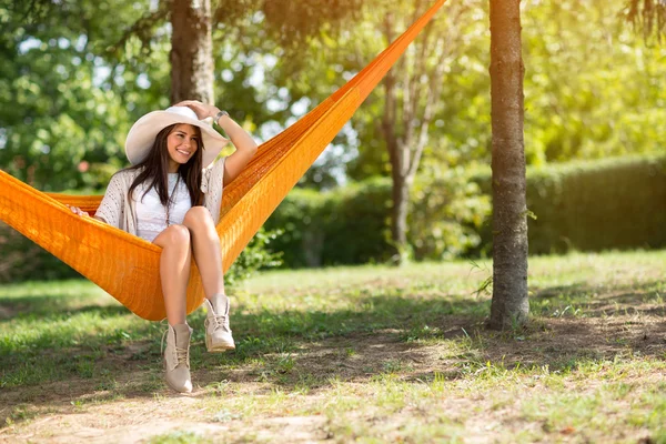 Signora con grande cappello seduta in amaca — Foto Stock