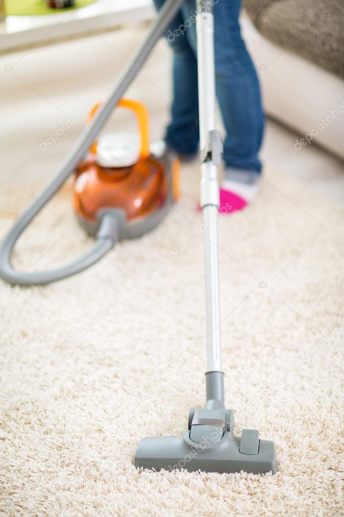 Vacuuming carpet with vacuum cleaner