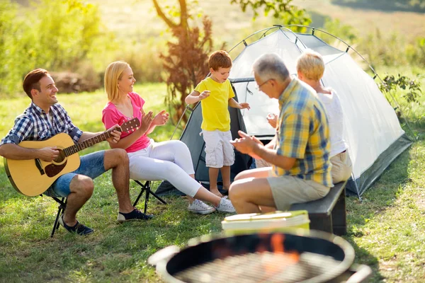 Child singing with smiling famil — Stock Photo, Image