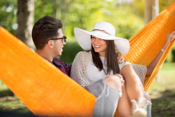 Guy with smiling girlfriend resting in hammock in wood — Stock Photo, Image