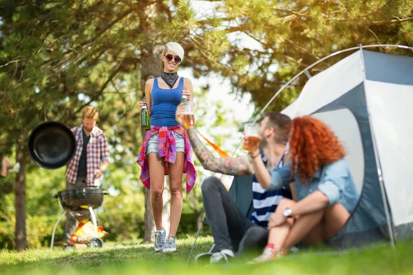 Torrada masculina e feminina com copos de cerveja com menina no acampamento — Fotografia de Stock