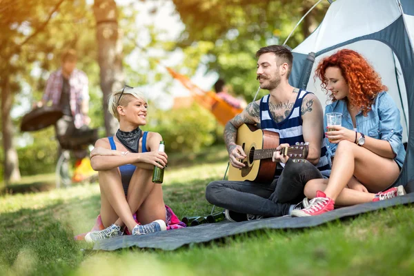 Jonge mensen geniet op excursie met bier en gitaar — Stockfoto