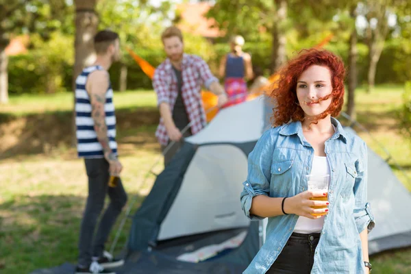 ユース キャンプにジンジャー ビールのグラスと女性が立っています。 — ストック写真
