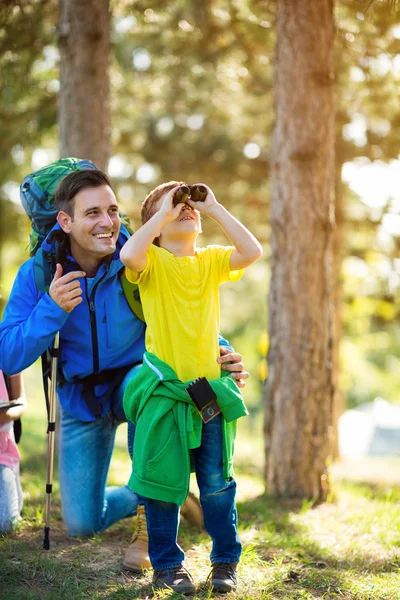 Pai e filho olhando através binocular — Fotografia de Stock