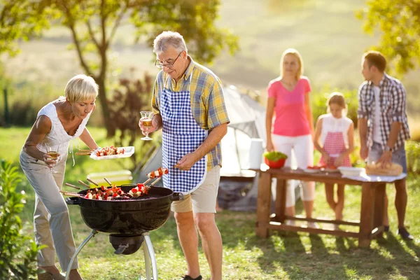 Grandmotherhelp grandfather baked on campfire — Stock Photo, Image