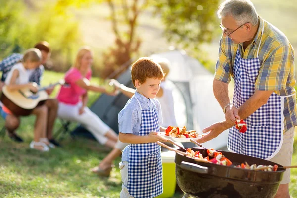 Nonno dando nipote carne alla griglia — Foto Stock