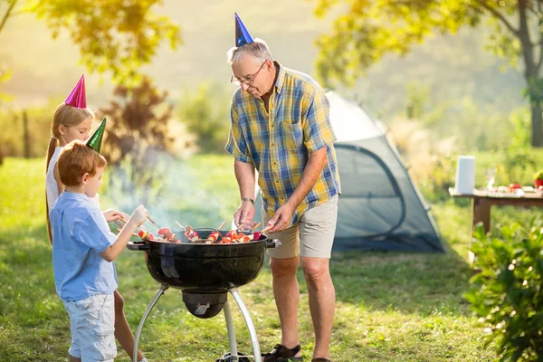 Kinderen en grootvader barbecue feest — Stockfoto