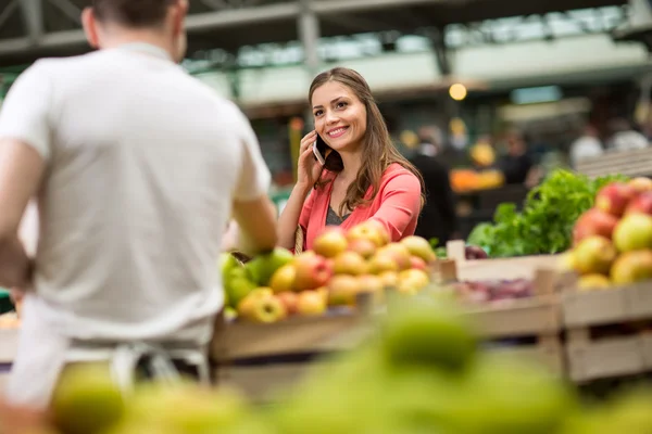 Woman with mobile phone at street market — Stockfoto