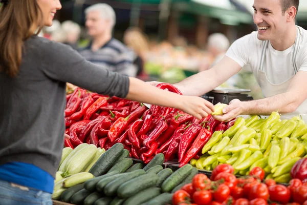 Vrouw verse groenten op straatmarkt kopen — Stockfoto