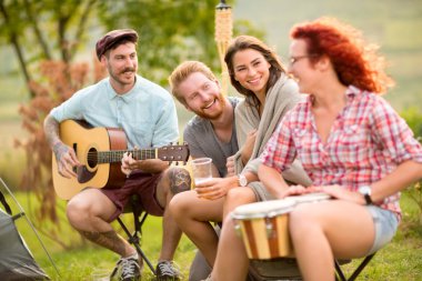 Neşeli erkek ve kız müzik aletleri kampında oynamak