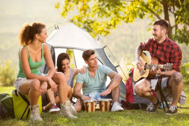 Group of people camping and singing