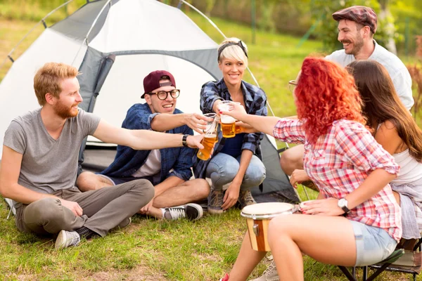 Manliga och kvinnliga Knacka med öl framför tält — Stockfoto