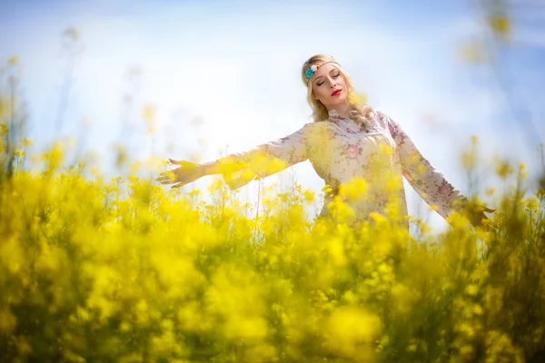 Belle femme en fleurs de colza oléagineux — Photo