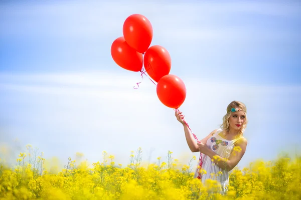 Hübsche Frau auf einem Blumenfeld — Stockfoto
