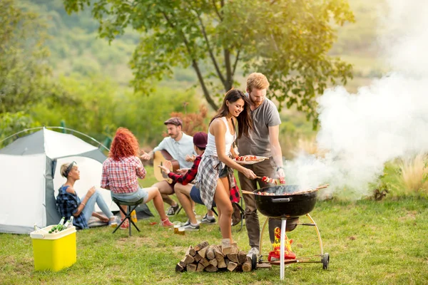 Unge kvindelige og mandlige par bagning grill - Stock-foto