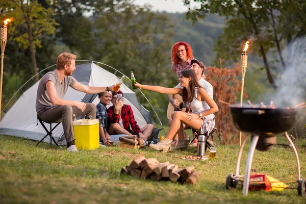 Chicos y chicas golpeando con botellas y de cerveza en el camping — Foto de Stock