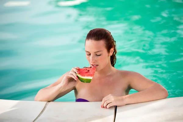 Porträtt av sexiga kvinna med bit vattenmelon på pool — Stockfoto