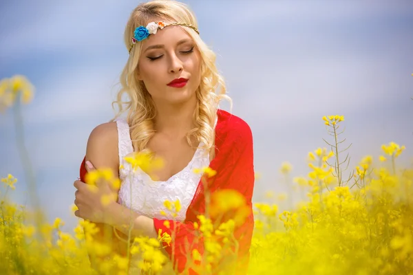 Portrait of beautiful woman in yellow flowers — Stock Photo, Image