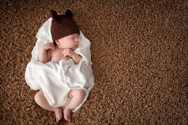 Serene newborn baby sleeping wrapped in diaper — Stock Photo, Image