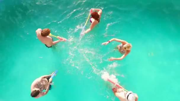 Voo aéreo: Grupo feliz de amigos desfrutando de festa na piscina de verão salpicando na água — Vídeo de Stock