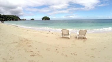 Hava uçuş: okyanus tarafından bir plajda iki boş sandalye