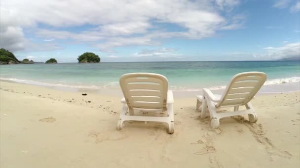 Воздушный полет: два Пустое кресло на пляже у океана — стоковое видео