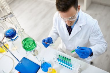 Koruyucu gözlük deney yapıyor taşıyan erkek bilim adamı