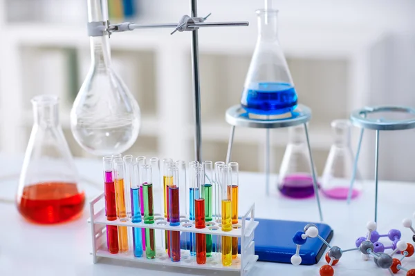 Escritorio en laboratorio de química con muestras en tubo de ensayo —  Fotos de Stock