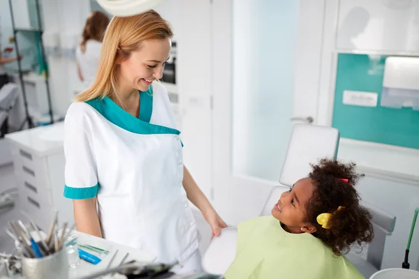 歯科医院で歯科助手と話しているかわいい女の子 — ストック写真