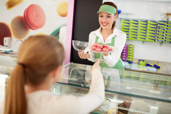 Saleswoman serves customer in pastry shop — Stock Photo, Image