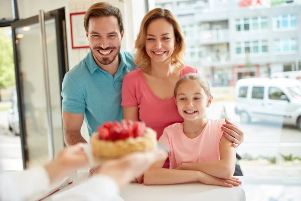 Familie kig på jordbærkage i bageri - Stock-foto