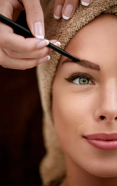 Pretty woman receiving professional make up — Stock Photo, Image