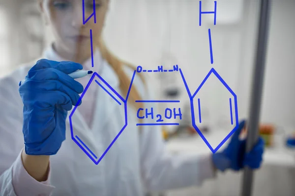 Científica femenina está dibujando reacción química en el glas —  Fotos de Stock