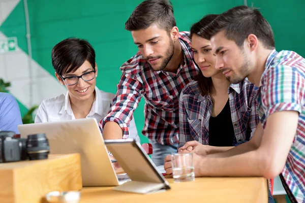 Young friends with laptop in coffee shop — Stock Photo, Image